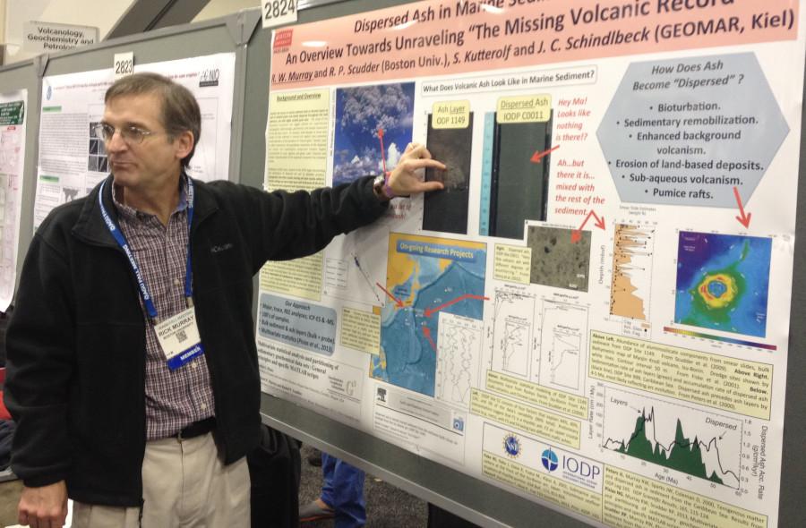 A professor from the AGU Conference explains his poster to a group of students.