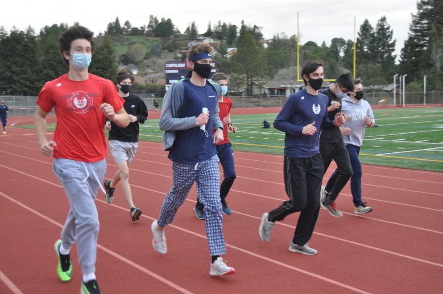 Seniors+Bradford+Martin+and+Jack+Pieper+run+with+masks+on+during+their+first+track+and+field+practice+of+the+school+year.