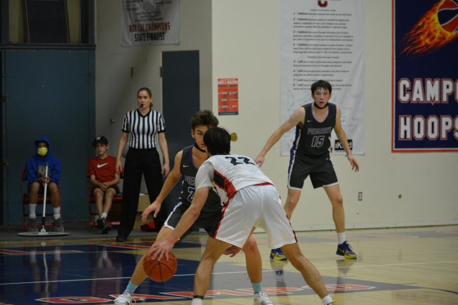 Cade Bennett dribbles the ball, preparing to overcome his defense.