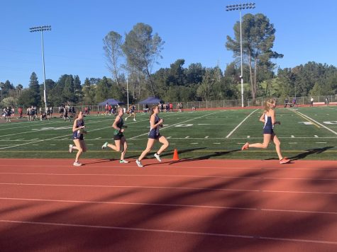 Junior Ellie Buckley and other track and field runners are going strong during their race.