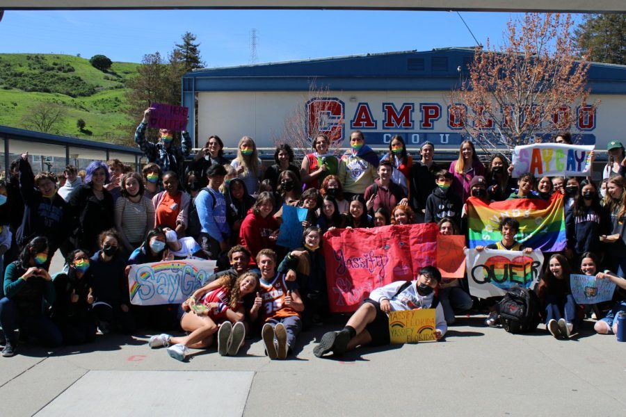 Students+participating+in+the+walkout+gather+for+a+group+picture+holding+their+pride+signs.