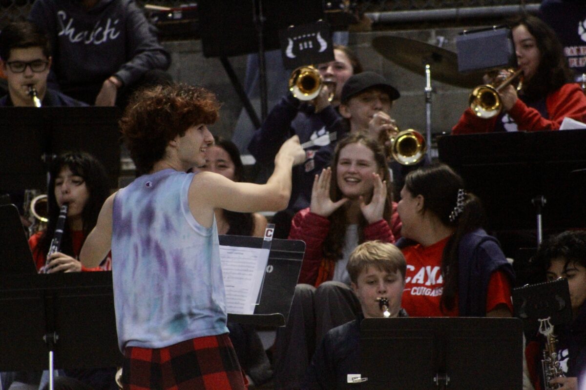 Senior Josh Larson conducts the band in the stands.
