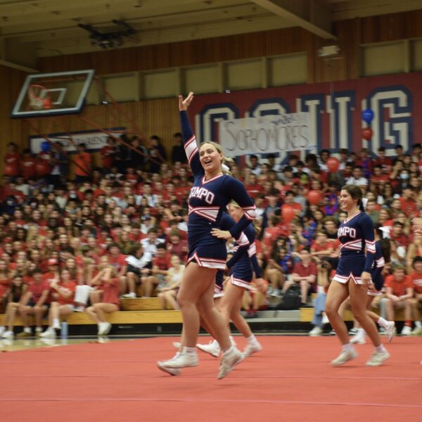 Senior Maggie Keough leads the competitive cheer team in greeting Campolindo rally-goers.