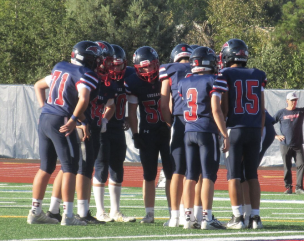 Freshman football players huddle up to strategize next play during game against Cal High.