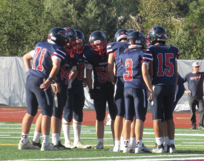 Freshman football players huddle up to strategize next play during game against Cal High.